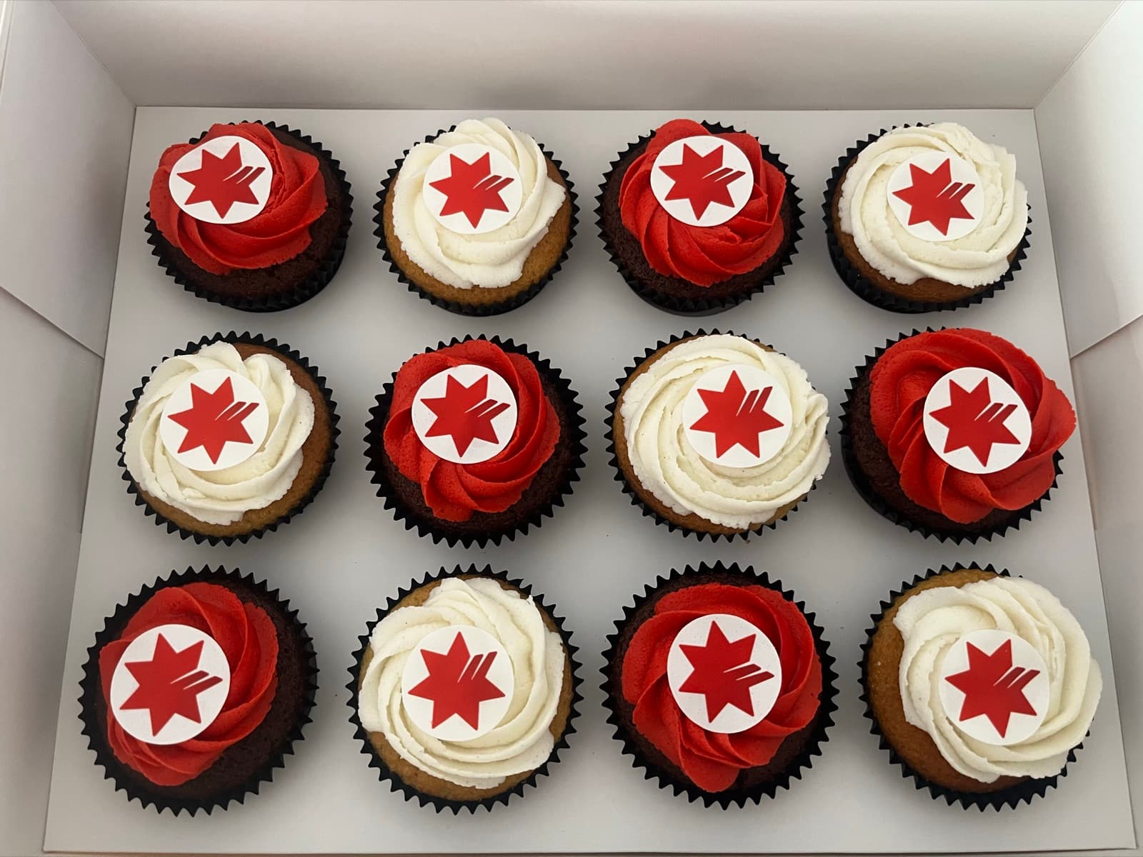 Custom cupcakes with red and white frosting and branded star toppers