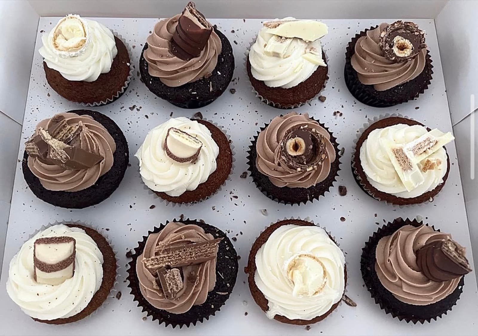 Chocolate cupcakes with cream and milk-chocolate toppers