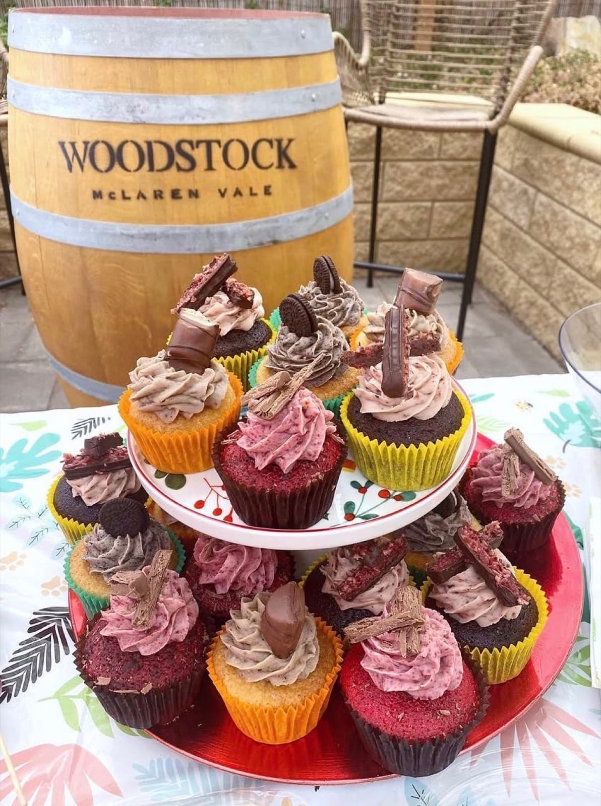 A tiered stand of assorted cupcakes set up for an event