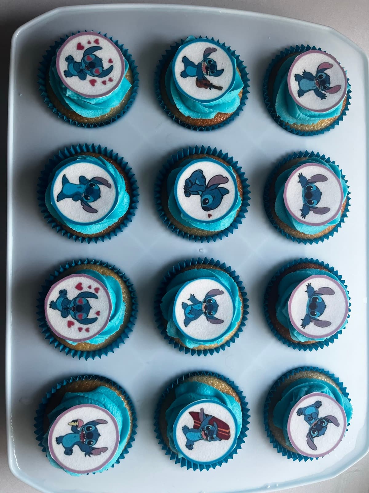 Character cupcakes with blue frosting and Stitch edible toppers