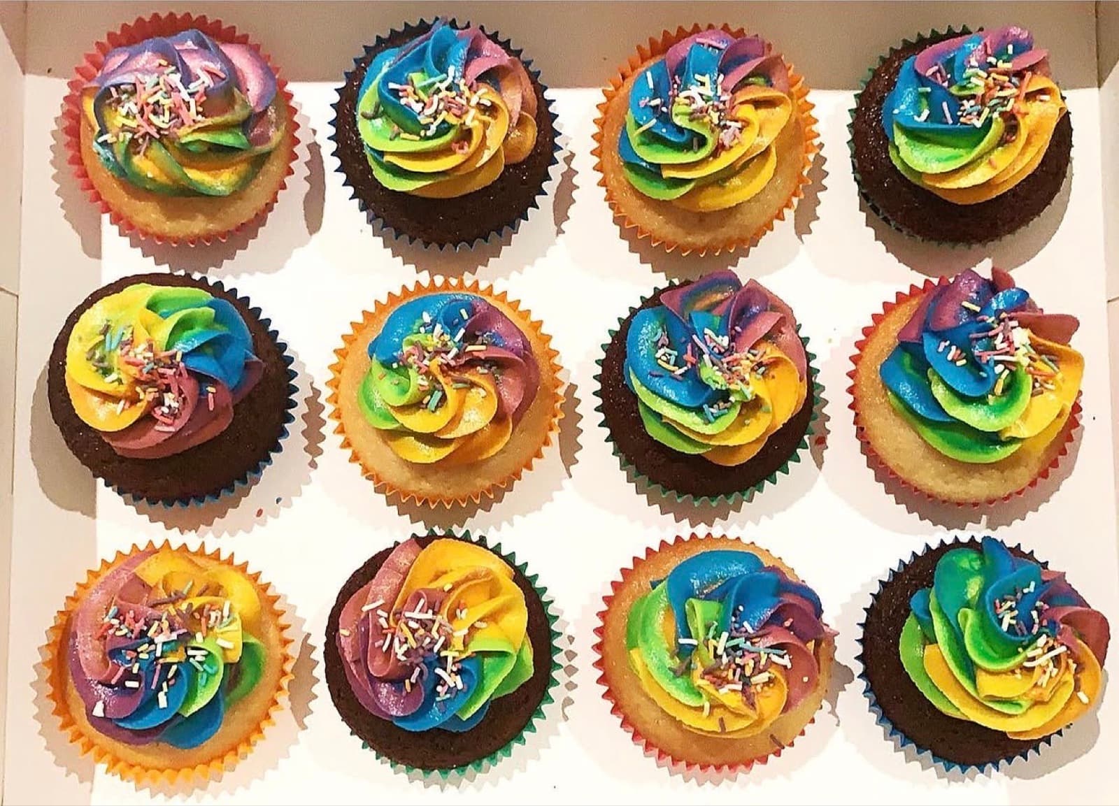 Tie-dye rainbow swirl cupcakes finished with sprinkles