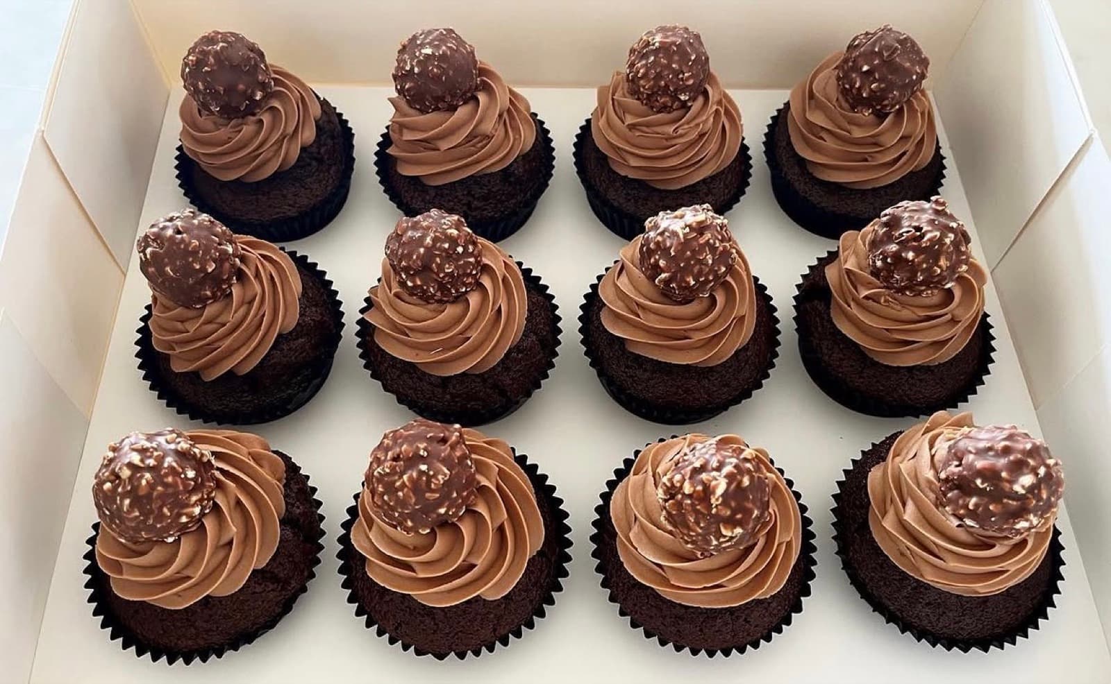 Chocolate cupcakes with mocha frosting, each topped with a whole Ferrero Rocher