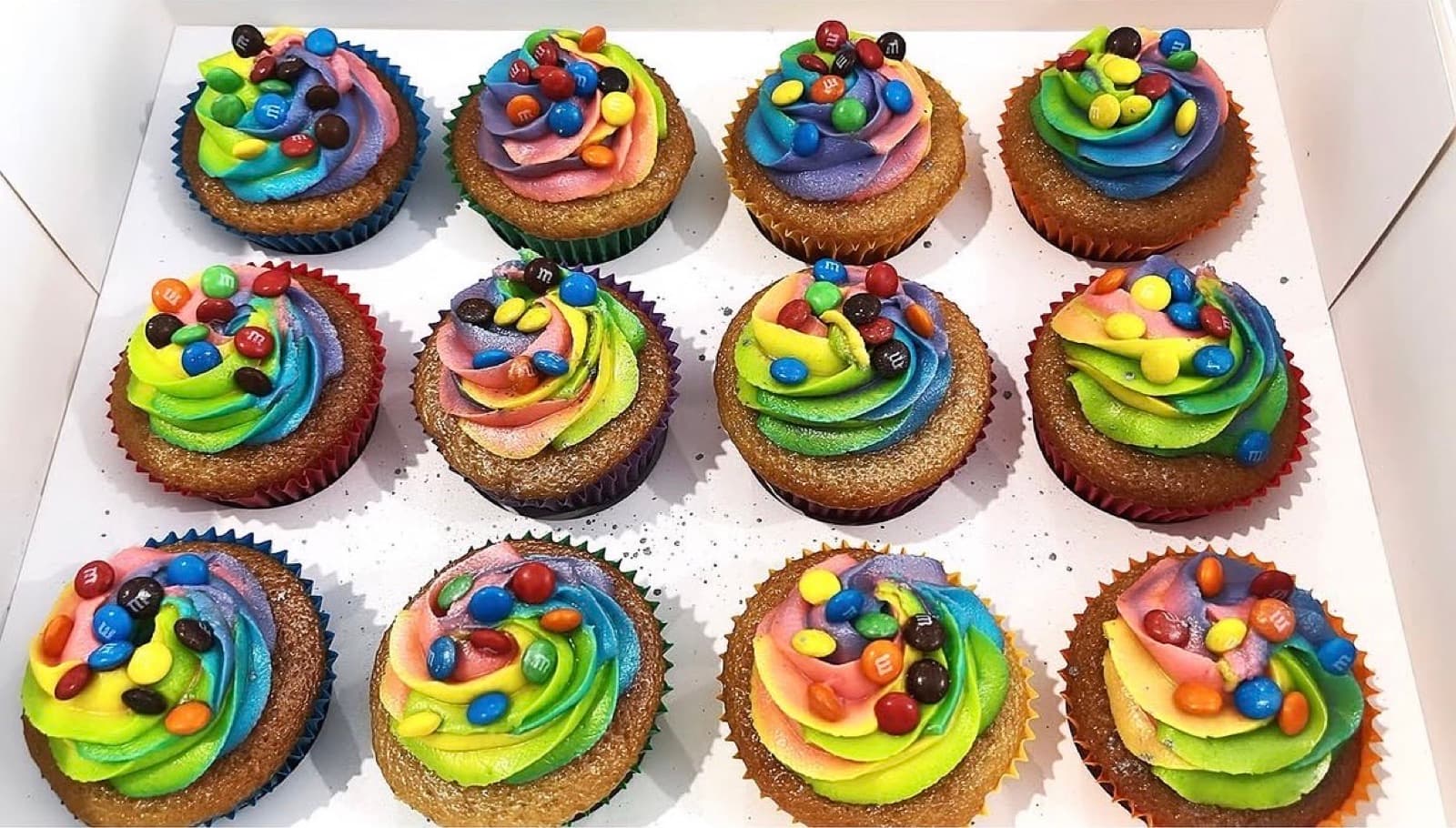 Rainbow buttercream cupcakes topped with colourful chocolate buttons